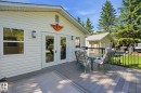 Expansive composite deck featuring a black metal railing and direct access via double French doors - 1410 47436 Range Rd. 15, Rural Leduc County, AB 