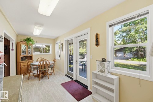 Bright dining area featuring light-toned flooring, two windows, and a glass-paneled exterior door - 1410 47436 Range Rd. 15, Rural Leduc County, AB 