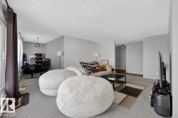 Living area featuring neutral gray wall paint and light gray carpeting - 