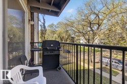 Private balcony featuring a black metal railing and a textured exterior wall - 