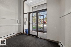 Entryway featuring extensive glazing, a robust metal-framed door system, and textured wall finishes - 