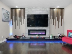Kitchen featuring dark wood-finish cabinetry, stainless steel appliances, dark stone countertops, and a tile backsplash - 