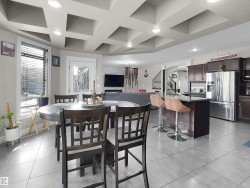 Upper landing featuring a contemporary chandelier, textured carpet flooring, and a window with opaque glass - 