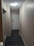 Entryway featuring wood-finish flooring, light tan wall color, a flush-mount ceiling light fixture, and white baseboards - 611 12831 66 Street, Edmonton, AB 