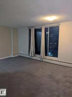 Wall-to-wall carpeting in a neutral tone, complemented by a large window feature with vertical blinds - 