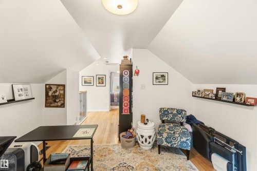 Loft area featuring vaulted ceilings, light wood-finish flooring, recessed lighting, and a partial hallway with a railing - 6036 106 Street, Edmonton, AB 