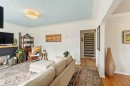Living area featuring a fireplace with a black surround, a textured blue ceiling, and recessed lighting - 6036 106 Street, Edmonton, AB 