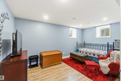 Recessed lighting illuminates this room featuring wood-finish flooring, light blue walls, and two visible windows - 6036 106 Street, Edmonton, AB 