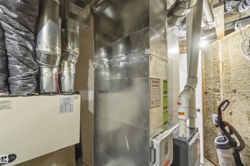 HVAC system featuring a large central duct, multiple insulated ducts, and exposed piping - 6036 106 Street, Edmonton, AB 