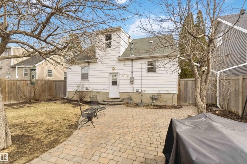 Rear exterior featuring white vinyl siding and multiple windows - 6036 106 Street, Edmonton, AB 