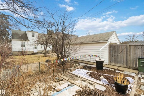 Detached garage with horizontal siding, a gabled roof, and wood fencing - 6036 106 Street, Edmonton, AB 