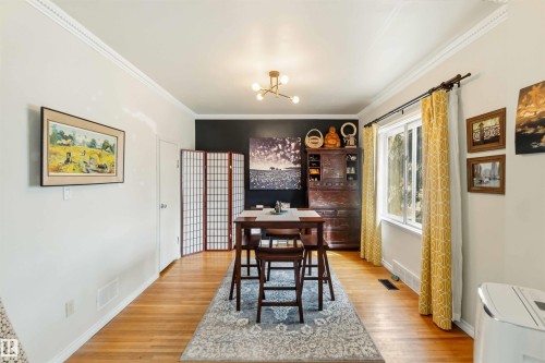 Hardwood flooring complementing light wall tones and a contrasting accent wall - 6036 106 Street, Edmonton, AB 