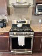 Stainless steel range with gas cooktop and matching overhead ventilation hood - 