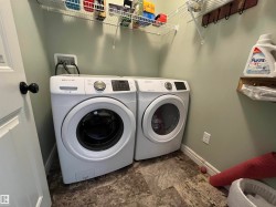Dedicated laundry area featuring wire shelving, wall-mounted rack with hooks, and durable flooring - 