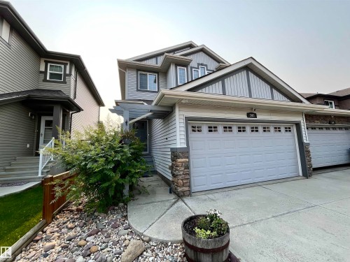 Contemporary two-story home featuring light gray siding and stone accents - 108 South Creek Wynd, Stony Plain, AB 