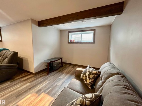 Finished lower level space featuring exposed wood-finish beam, recessed lighting, and wood-finish flooring - 108 South Creek Wynd, Stony Plain, AB 