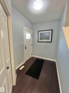 Entryway featuring a paneled door with frosted glass, wood-finish flooring, and light blue wall paint - 