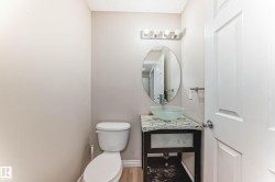 Bathroom vanity featuring a frosted glass vessel sink, chrome faucet, and oval mirror - 