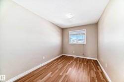 Light-filled interior space featuring wood-finish flooring, neutral wall tones, and white trim - 