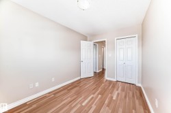 Room featuring wood-finish flooring, light neutral wall tones, and white trim - 