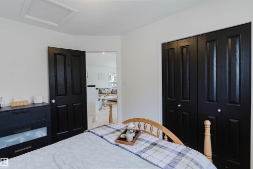 Bedroom with white walls and dark paneled doors - 1743 Melrose Crescent Sw, Edmonton, AB 