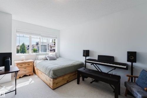 Bright room featuring a large window with horizontal blinds, neutral wall paint, and light-colored carpet - 1743 Melrose Crescent Sw, Edmonton, AB 