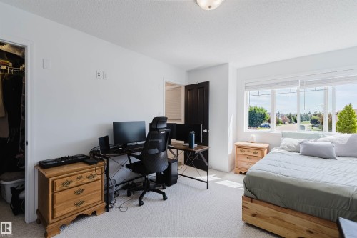 Bedroom featuring large windows, white walls, and light-colored carpet flooring - 1743 Melrose Crescent Sw, Edmonton, AB 