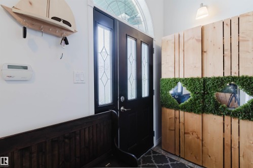 Entryway featuring a black door with decorative glass inserts and an arched transom window - 1743 Melrose Crescent Sw, Edmonton, AB 