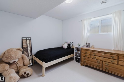 Bright room with white walls, a single window with white curtains, recessed lighting, and light-colored carpeting - 1743 Melrose Crescent Sw, Edmonton, AB 