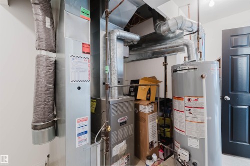 Utility area featuring a Lennox furnace, Smith water heater, and extensive ductwork - 1743 Melrose Crescent Sw, Edmonton, AB 