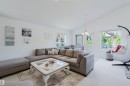 Vaulted ceiling living area featuring light-colored carpeting, multiple windows providing ample natural light, and a built-in banquette dining area - 1743 Melrose Crescent Sw, Edmonton, AB 