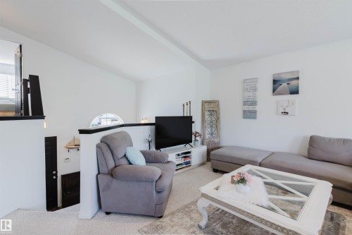 Vaulted ceilings enhance this living area with white walls and light-toned carpet - 1743 Melrose Crescent Sw, Edmonton, AB 