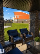 Covered patio area featuring stone-clad pillars and a textured ceiling - 