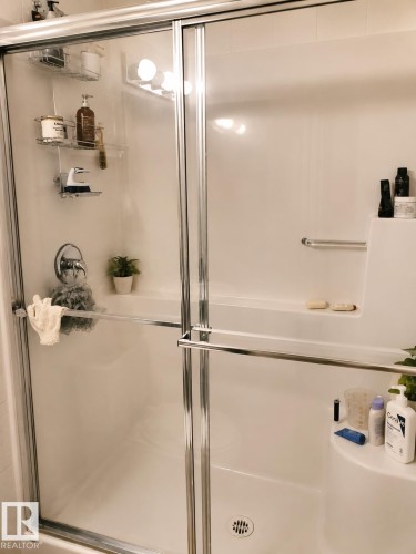 Shower enclosure with sliding glass doors and polished chrome framing - 128 1510 Watt Drive Sw, Edmonton, AB 