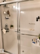Shower enclosure with sliding glass doors and polished chrome framing - 