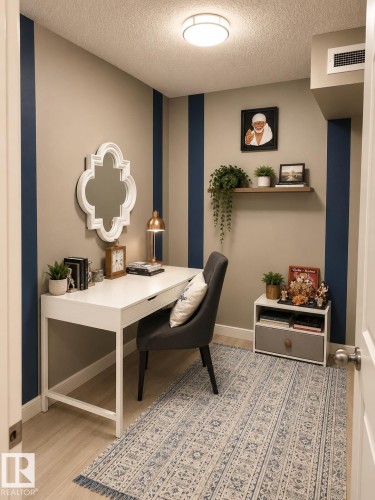 Compact room featuring light-toned flooring and contrasting vertical wall accents - 128 1510 Watt Drive Sw, Edmonton, AB 