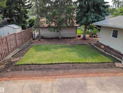 Private backyard featuring a freshly sodded lawn, perimeter fencing, and mature trees - 