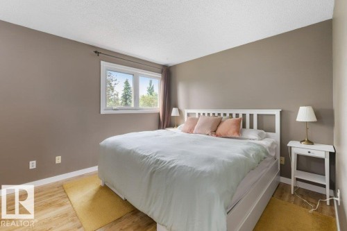 Spacious bedroom featuring warm neutral wall tones and wood-finish flooring - 18609 54 Avenue, Edmonton, AB 