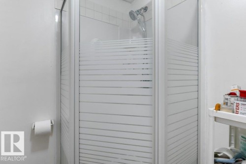 Corner shower enclosure with frosted glass panels and a chrome shower head - 18609 54 Avenue, Edmonton, AB 