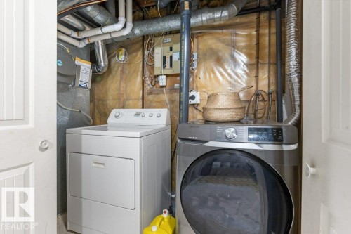 Dedicated utility area featuring a white top-load washing machine and a grey front-load dryer - 18609 54 Avenue, Edmonton, AB 