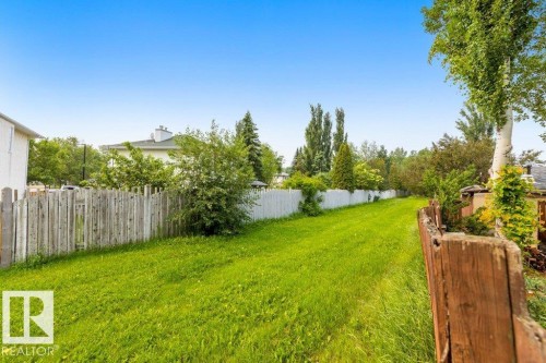 Expansive grassy area bordered by wood fencing and mature trees - 18609 54 Avenue, Edmonton, AB 
