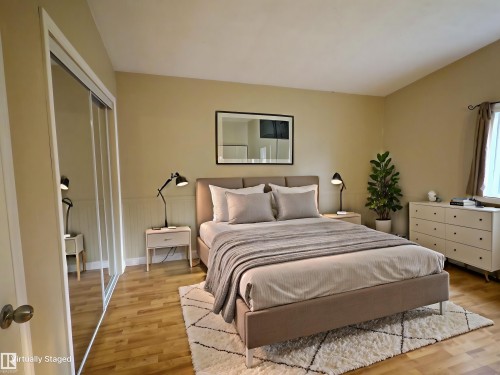 Bedroom featuring wood-finish flooring, a wall-mounted mirror, and wainscoting - 79 Grosvenor Boulevard, St. Albert, AB 