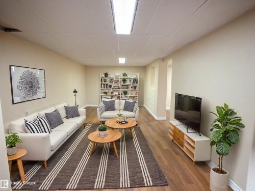 Spacious room featuring wood-finish flooring, light neutral wall tones, and recessed ceiling lighting - 79 Grosvenor Boulevard, St. Albert, AB 