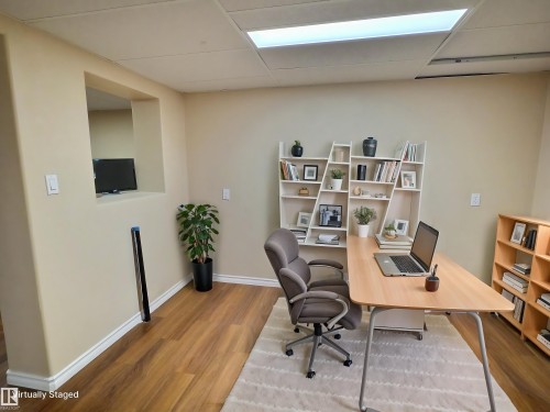 Versatile room featuring wood-finish flooring, neutral-toned walls, a built-in wall niche, and recessed ceiling lighting - 79 Grosvenor Boulevard, St. Albert, AB 