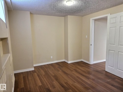 Room featuring wood-finish flooring, neutral wall tones, and white baseboards - 79 Grosvenor Boulevard, St. Albert, AB 