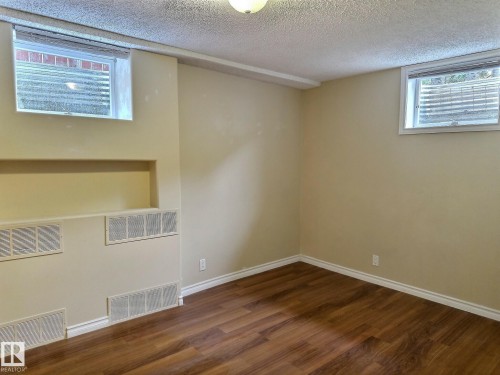 Room featuring wood-finish flooring, neutral wall paint, and white trim - 79 Grosvenor Boulevard, St. Albert, AB 