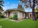 Mid-century modern exterior featuring a low-pitch roofline, stucco siding, and a prominent picture window - 79 Grosvenor Boulevard, St. Albert, AB 