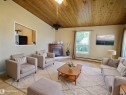 Living area featuring a wood-finish plank ceiling, a built-in fireplace with a dark wood mantel, and light wood-finish flooring - 79 Grosvenor Boulevard, St. Albert, AB 