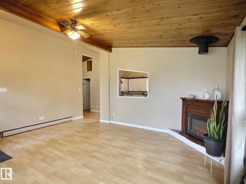 Open concept living space featuring a wood-finish ceiling, exposed beam, ceiling fan, and wood-finish flooring - 79 Grosvenor Boulevard, St. Albert, AB 