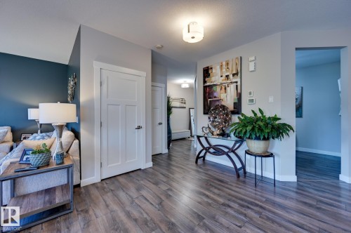 Hallway featuring wood-finish flooring, white trim, and a contemporary ceiling light fixture - 101 Hilldowns Drive, Spruce Grove, AB 